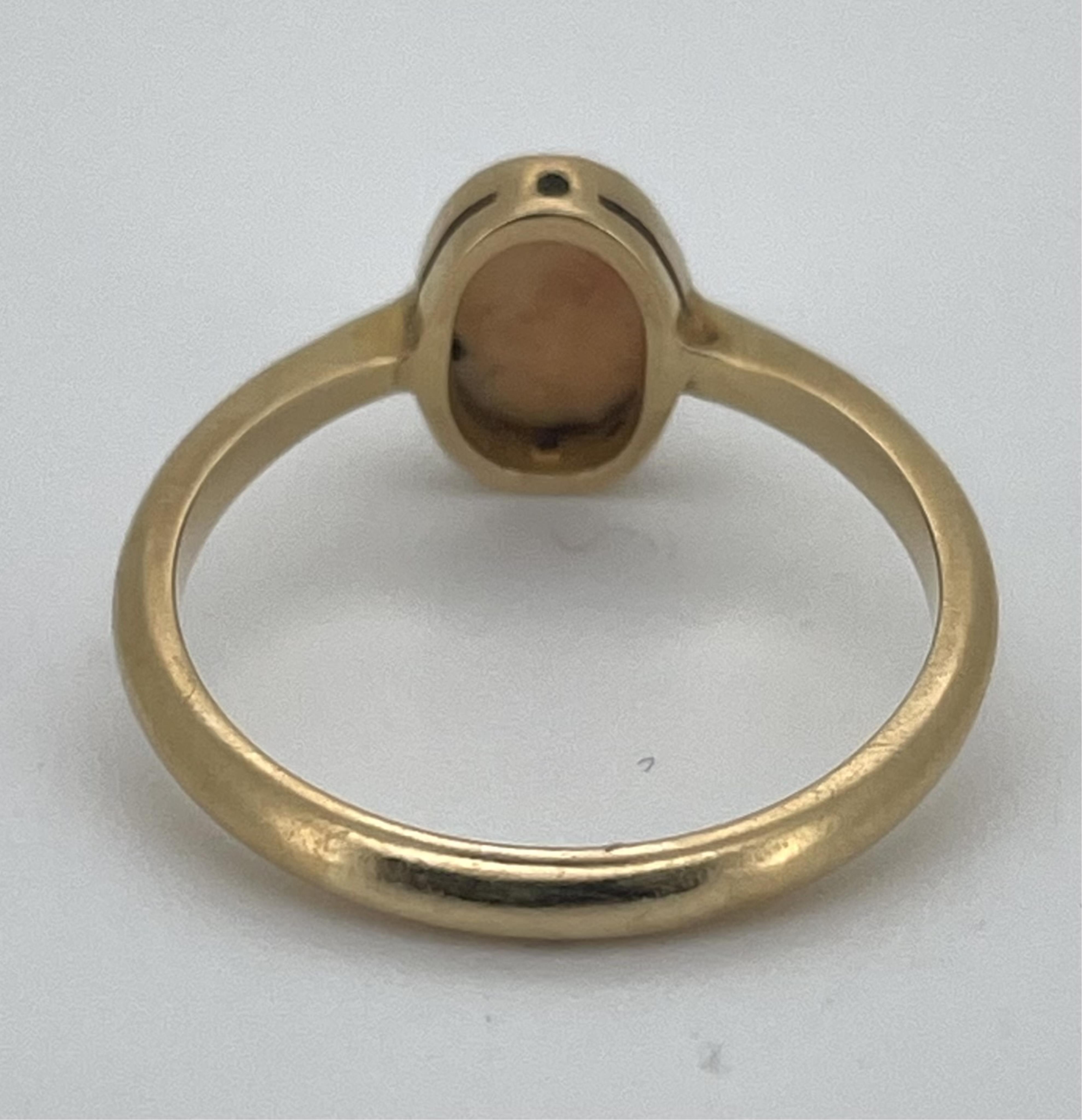 A 1970's 18ct gold and single stone oval white opal set ring, size L, gross weight 2.5 grams.